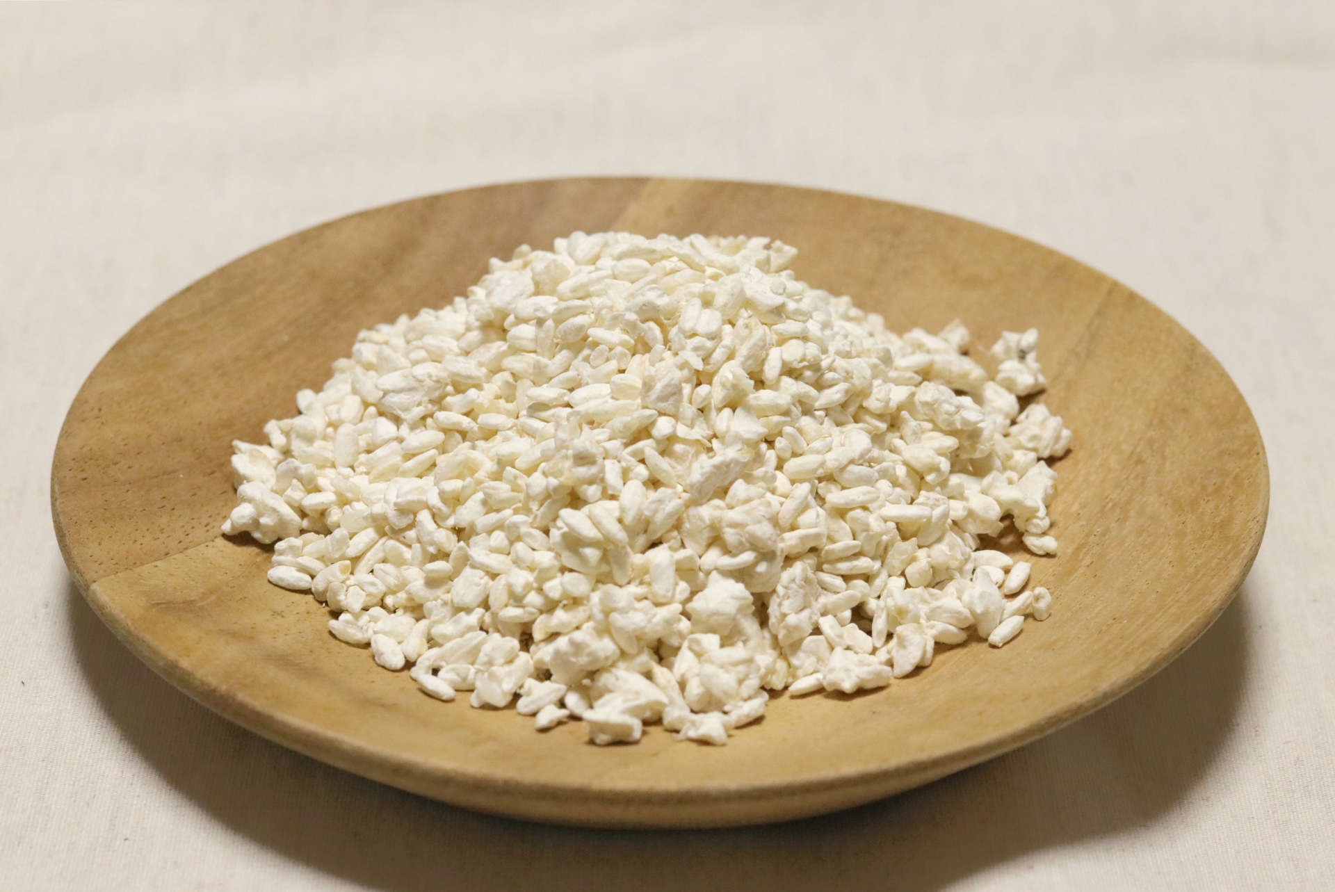 木のお皿に広げた米麹の写真。発酵の原点となる麹から、腸と肌を内側から育てるイメージ。